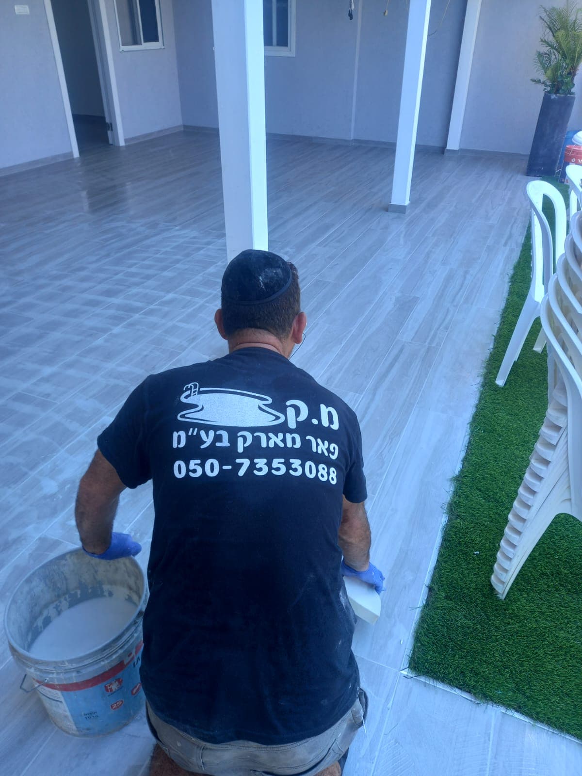 איש מקצוע ממ.ק פאר מארק מבצע איטום וגימור על ריצוף במרפסת